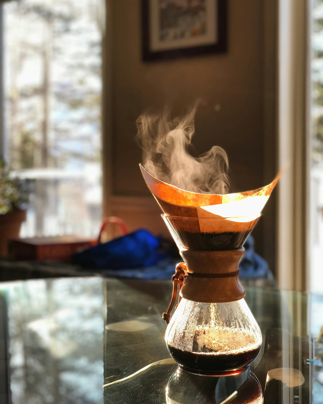 Pour-over coffee dripper with steam rising, morning light